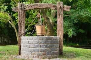 Old water well with pulley and bucket