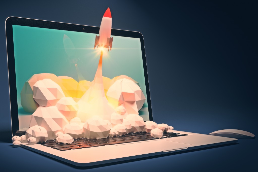 laptop with 3D graphics of rocket taking off popping out of the screen