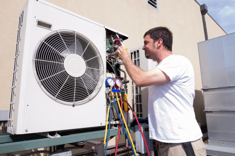 man fixing hvac system of a house