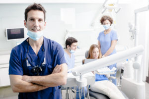 a dentist with his team working in the background