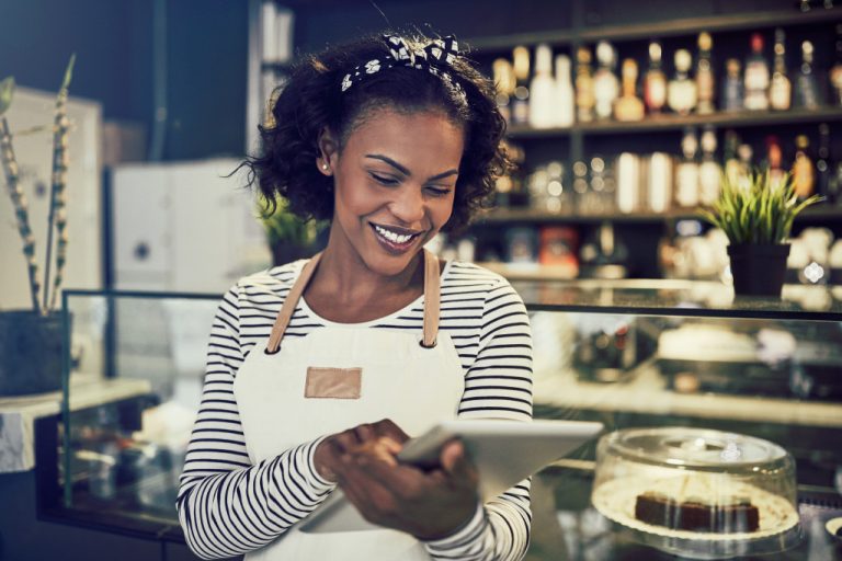 businesswoman smiling while using tablet at the shop
