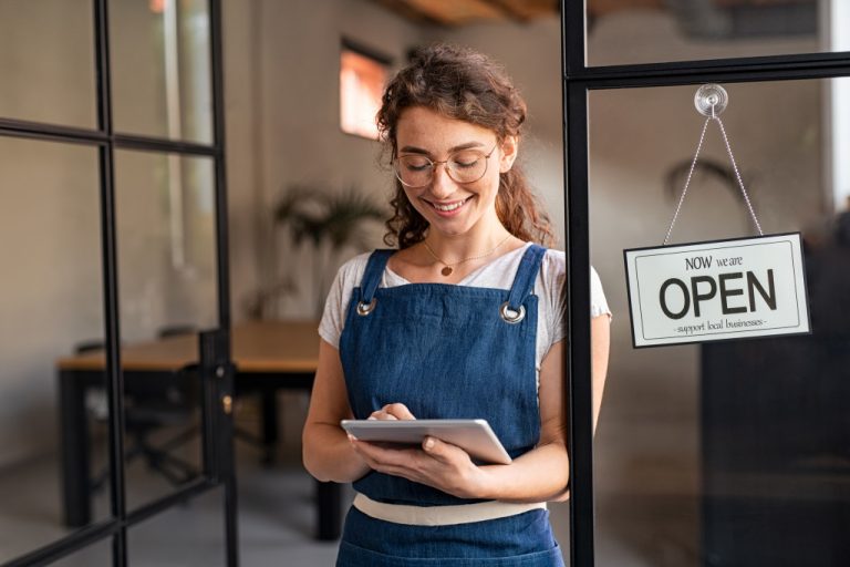 A small business owner in her store's entrance
