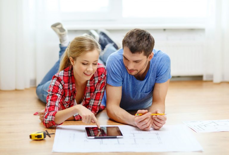 smiling couple looking at tablet pc at home