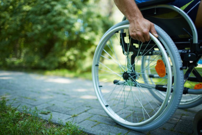 A man with his hands on the wheel of his wheelchair