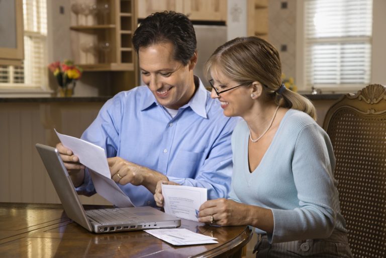 Mature couple checking their finances at home.